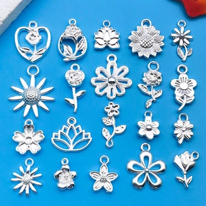 Macro-opname van diverse antieke zilveren bloemenhangers en hartbedels op blauw