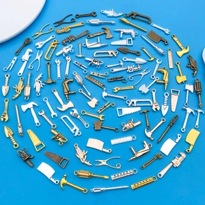 Detalle de colgantes de herramientas en miniatura de aleación en tres tonos metálicos