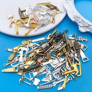 Vista macro de mini dijes de herramientas de aleación variadas para creación de joyas DIY