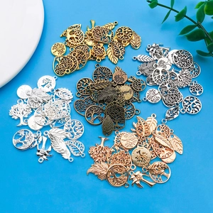 Detailweergave van DIY bedeltjes met levensboom en vogels voor het maken van sieraden