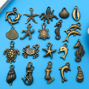 Detalle macro de varios dijes marinos de bronce para la creación de joyas artesanales