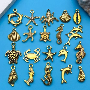 Vista de detalle de 19 dijes marinos dorados con sirenas y tortugas para joyería DIY