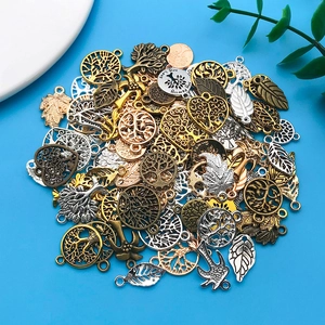Macro-opname van vintage legering bedeltjes met levensboom en bladmotieven in diverse kleuren