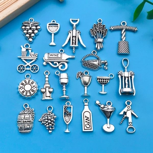 Platliggende weergave van 20 vintage zilverlegering wijn en druiven hangers op blauw