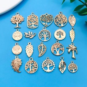 Platte weergave van 20 goudkleurige levensboom en bladhangers voor DIY sieraden