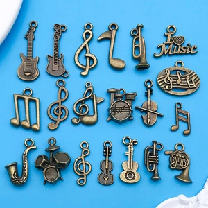 Detalle de colgantes de música vintage en bronce con instrumentos sobre fondo azul
