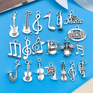 Detalle de 18 dijes musicales de plata con guitarra y tambores sobre fondo azul