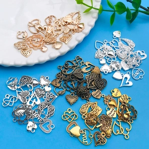 Detailopname van diverse hart- en vleugelbedeltjes van metaal voor DIY sieraden maken