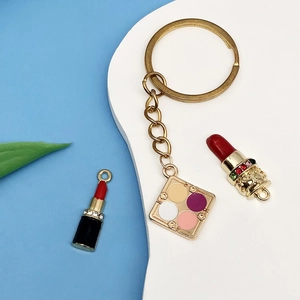 Detail of colorful enamel makeup charms including eyeshadow palette and lipsticks