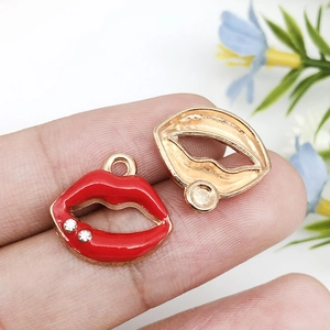 Detailed view of red enamel lip charms with gold plating and rhinestones for DIY jewelry