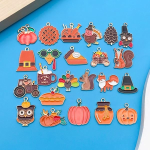 Detalle de dijes esmaltados de Acción de Gracias con pavos y calabazas para creación de joyas