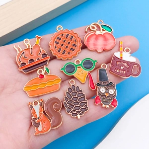 Macro shot of 10-piece enamel fall charms including pumpkins, owls and turkey for DIY jewelry