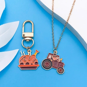 Detalle de dijes esmaltados de Acción de Gracias con llavero de pavo y collar de tractor