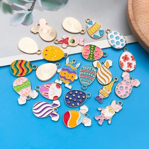 Detail of colorful Easter enamel charms with bunnies and eggs on blue background