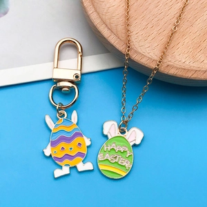 Detail showing Easter bunny egg charms on gold keychain and necklace with Happy Easter text