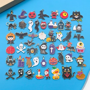 Detalle de dijes esmaltados de Halloween con diseños de calabaza, fantasma y murciélago