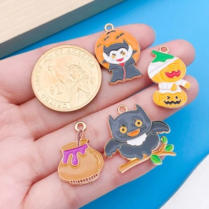 Detalle de los dijes esmaltados de Halloween con moneda de dólar como referencia de talla