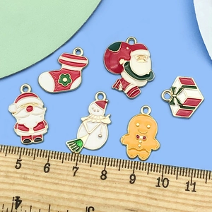 Detalle de dijes navideños coloridos con Papá Noel y muñeco de nieve junto a una regla