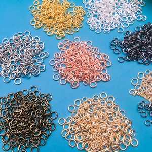 Anellini aperti in metallo misto per gioielli fai-da-te su sfondo blu acceso