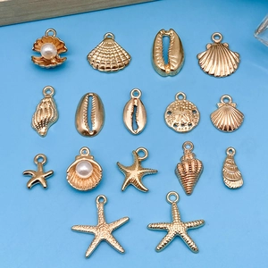 Golden sea life alloy pendants set with starfish, shells and pearls on blue background