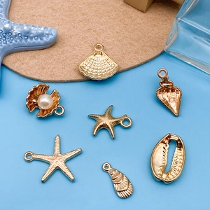 Golden ocean theme charms featuring starfish and shells on a blue background and felt mat