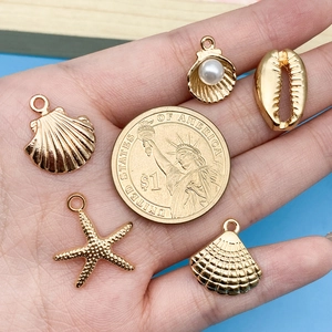 Golden ocean sea shell starfish charms set with pearl detail and coin for size reference