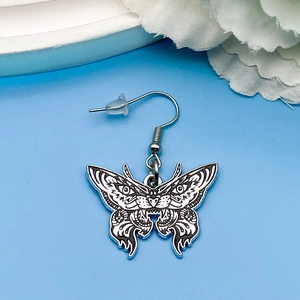 Detalle de pendiente de mariposa gótica con arte lineal en blanco y negro y gancho