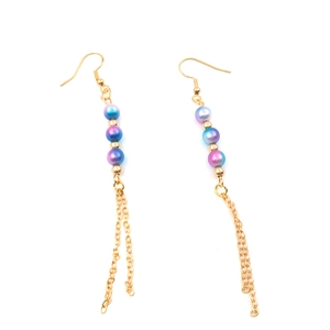 Detail of elegant gold drop earrings with gradient colorful beads and delicate tassels