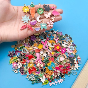 Macro view of colorful alloy enamel charms being held in hand for DIY jewelry making