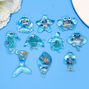 Macro shot of 10 translucent blue ocean animal resin charms with glitters for DIY keychain