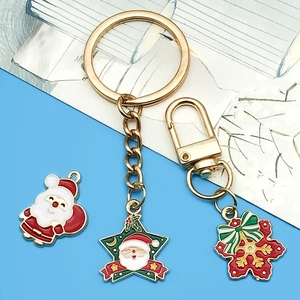 Vue détaillée de pendentifs de Noël en alliage avec Père Noël, étoile et flocon rouge