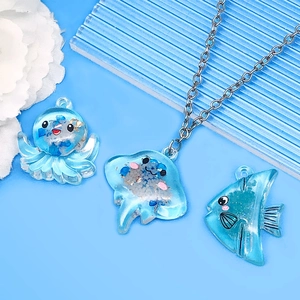Close-up of blue acrylic ocean creature charms with glitter and silver metal chains