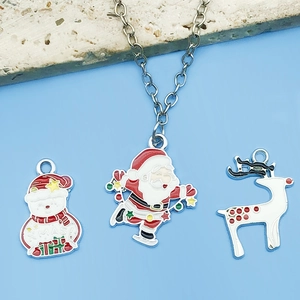 Vista detallada de colgantes navideños de esmalte de colores con Papá Noel y muñeco de nieve