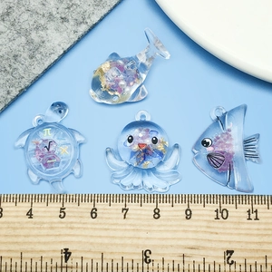 Pendentifs créatures marines en résine violette avec fleurs séchées et dorure