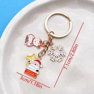 Detailed view of gold metal Christmas keychain with Santa, snowman and snowflake charms