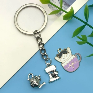 Detail view of cartoon cat coffee cup and vintage silver teapot charms for DIY jewelry