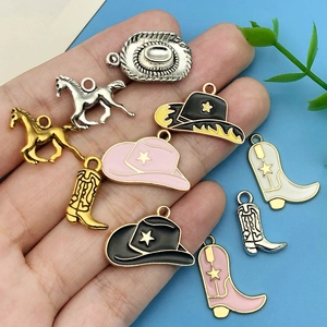 Pink and black cowboy hat and boot charms for DIY jewelry held in hand for size