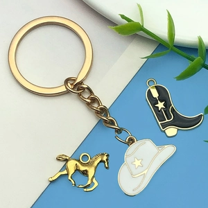 Detail of western keychain with gold horse, cowboy hat, and black boot enamel charms