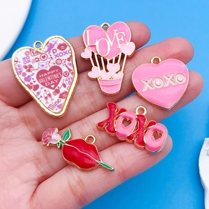 Macro-opname van roze hartballon en XOXO bedeltjes voor DIY Valentijnsdag sieraden