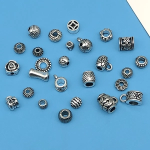 Macro view of assorted antique silver alloy spacer beads and floral jewelry components