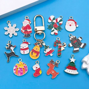 Detalle de dijes navideños esmaltados surtidos con Papá Noel, alces y copos de nieve