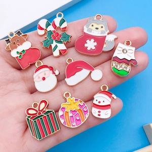 Detalle de dijes navideños esmaltados con Papá Noel y alce para creación de joyas caseras