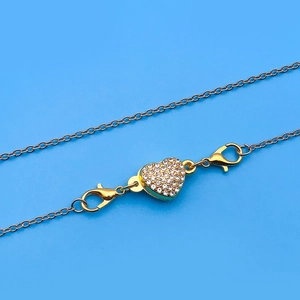 Macro view of gold heart magnet clasp with rhinestones and lobster claw connectors