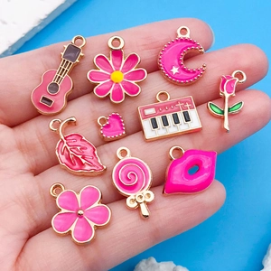 Macro shot of assorted rose pink enamel charms including guitars and flowers for DIY jewelry