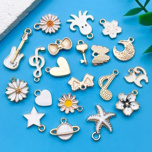 DIY jewelry charm set with white enamel guitar and music notes on blue background