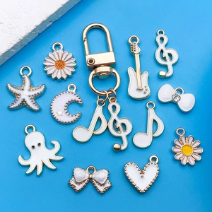 Detailed view of assorted white enamel alloy charms like stars and music notes for DIY jewelry