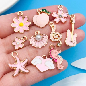 Close-up of pink enamel charms set including flowers, hearts, and musical notes icons