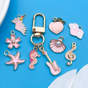 Detail of pink enamel charms set with unicorn, guitar and heart for DIY jewelry making