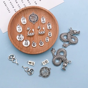 Macro shot of retro silver alloy charms with Chinese auspicious clouds and hollow gourds