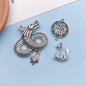 Detailed macro view of vintage silver alloy dragon charms and hollowed Fu character pendant